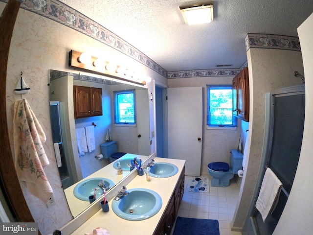 bathroom featuring toilet, a textured ceiling, vanity, and plenty of natural light