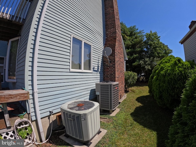 view of side of home with cooling unit and a yard