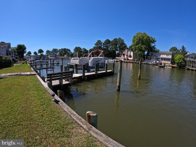 view of dock featuring a lawn and a water view