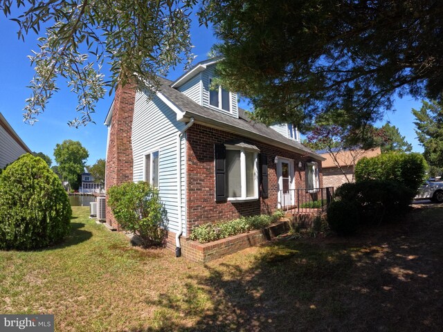 view of side of property with central AC and a yard