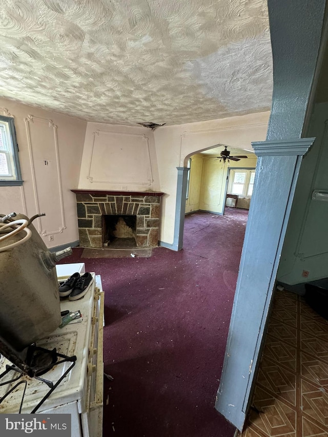 miscellaneous room with a fireplace, a textured ceiling, and ceiling fan