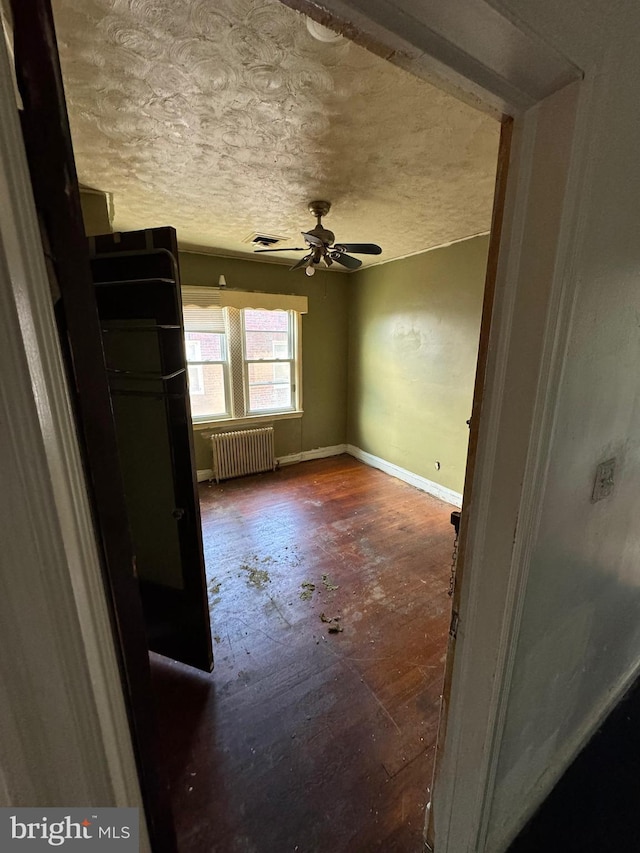 empty room with radiator and ceiling fan