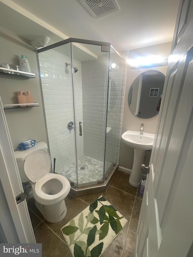 bathroom with tile patterned floors, an enclosed shower, and toilet