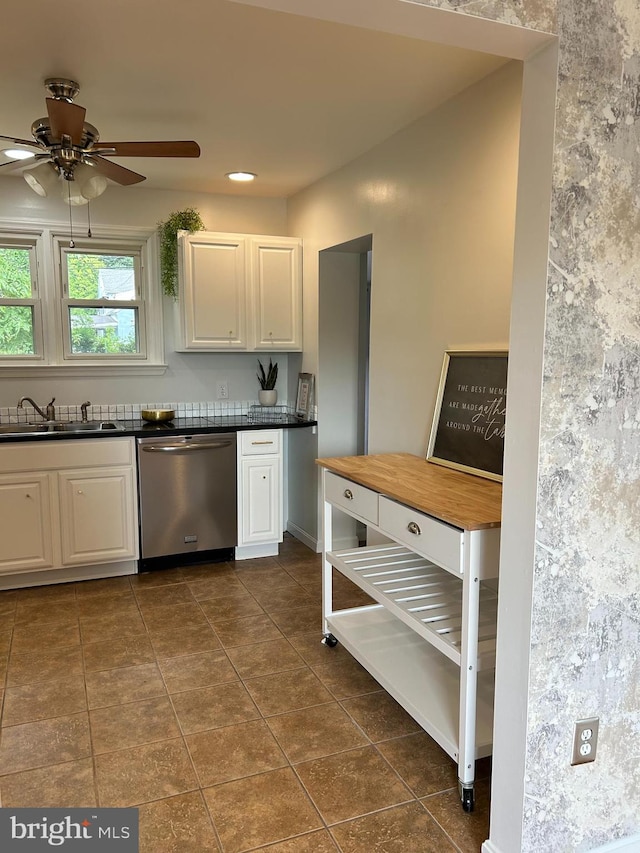 kitchen with white cabinets, dishwasher, ceiling fan, dark tile patterned flooring, and sink