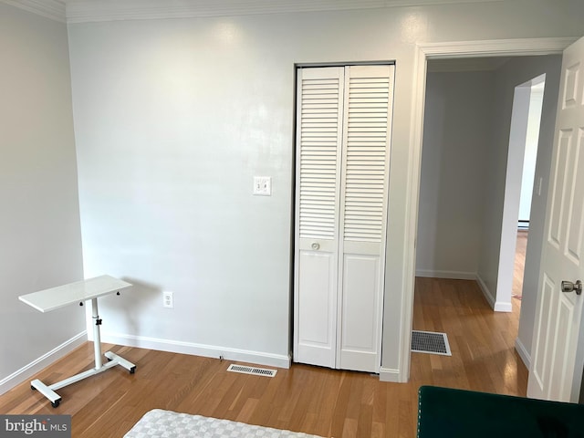 interior space with wood-type flooring and ornamental molding