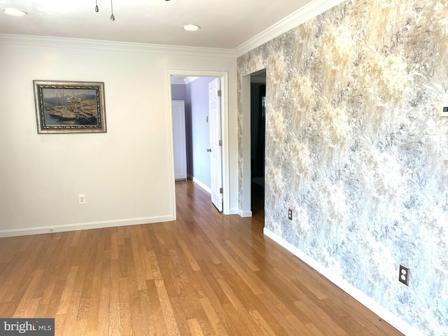 spare room with hardwood / wood-style flooring and ornamental molding