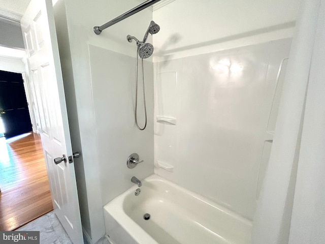 bathroom with shower / washtub combination and hardwood / wood-style floors