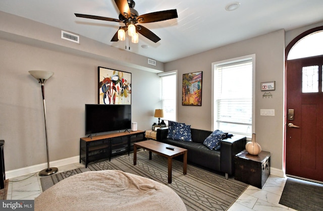 living room featuring plenty of natural light and ceiling fan