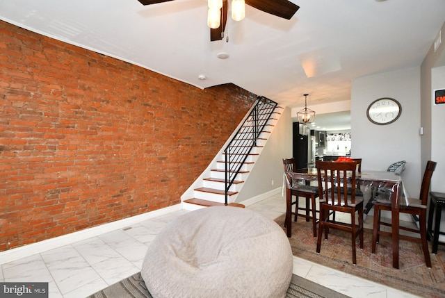 dining room featuring ceiling fan and brick wall