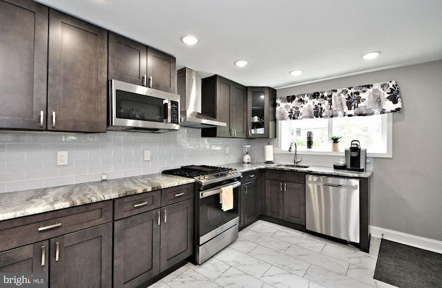 kitchen featuring backsplash, wall chimney range hood, sink, appliances with stainless steel finishes, and dark brown cabinets