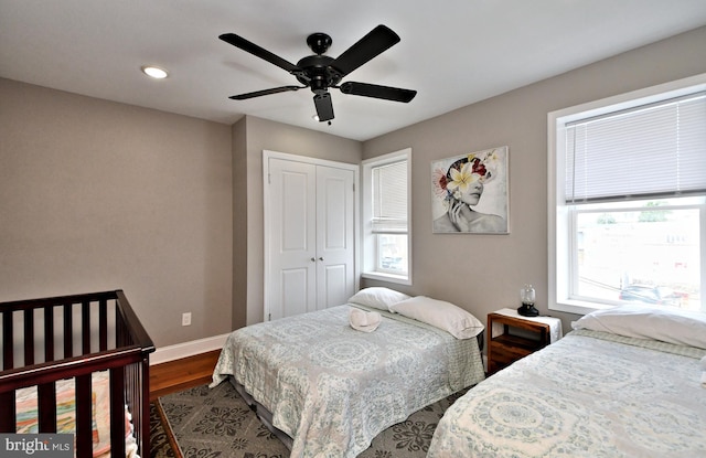 bedroom with ceiling fan, wood-type flooring, and a closet