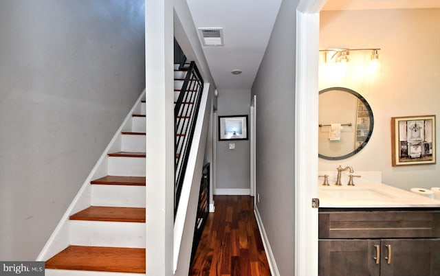 staircase with hardwood / wood-style flooring and sink