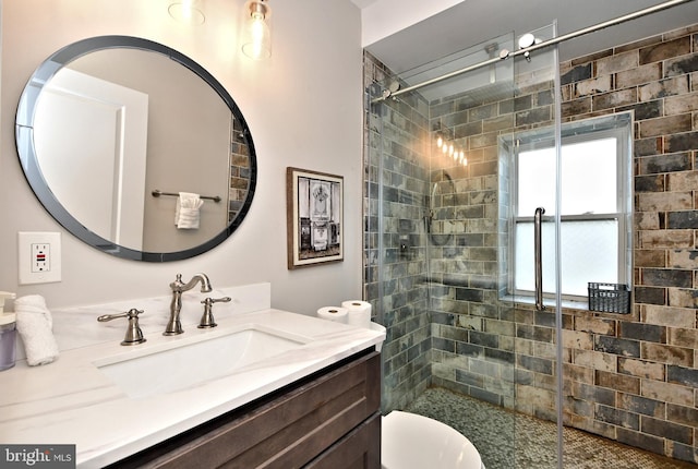 bathroom with tiled shower, vanity, and toilet