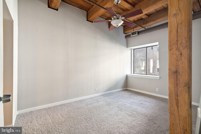 spare room with beam ceiling, ceiling fan, carpet flooring, and wood ceiling