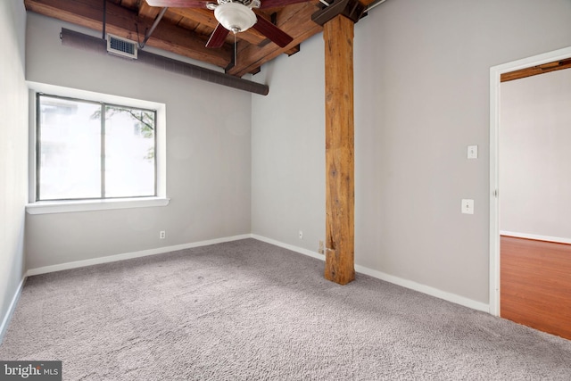 unfurnished room featuring carpet, ceiling fan, wooden ceiling, and beamed ceiling