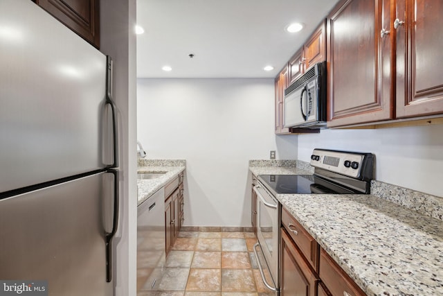 kitchen with light stone counters, sink, and stainless steel appliances