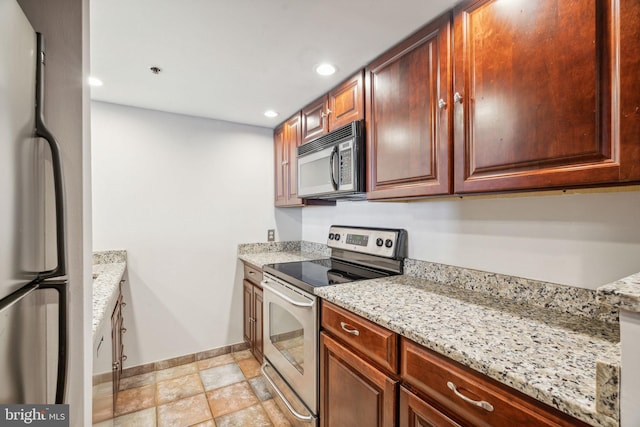 kitchen with light stone counters and appliances with stainless steel finishes