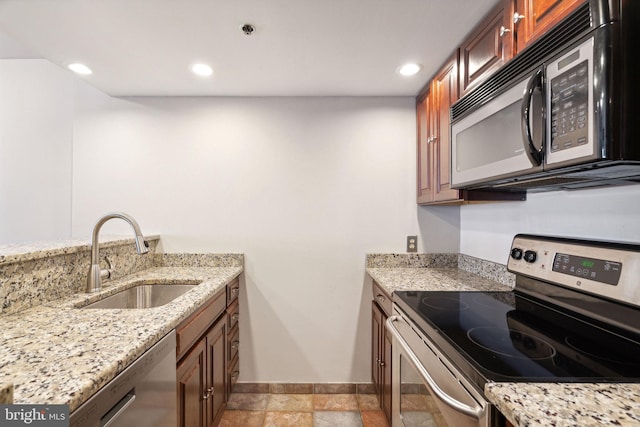 kitchen featuring light stone counters, sink, and stainless steel appliances