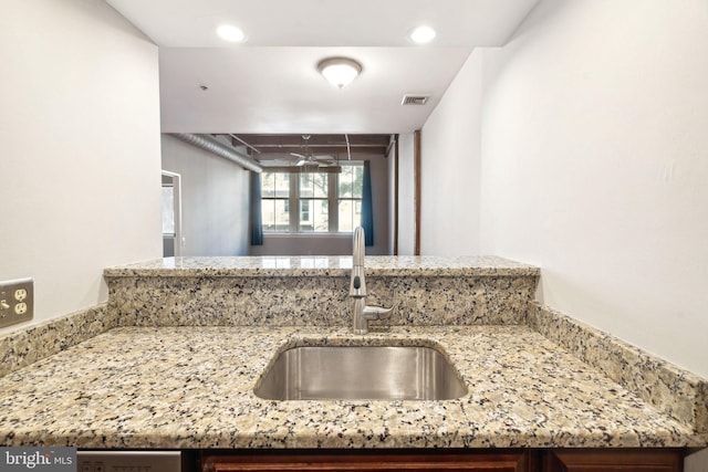 kitchen with light stone countertops and sink