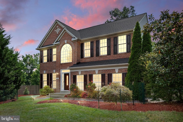 colonial inspired home with a lawn