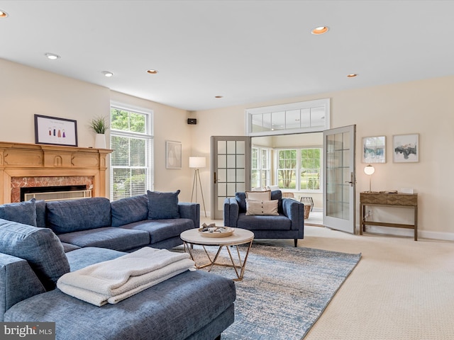 carpeted living room featuring a premium fireplace and french doors