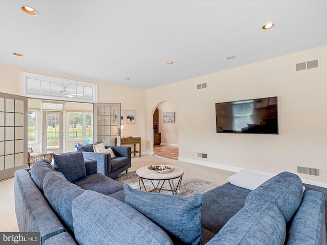 carpeted living room with ceiling fan