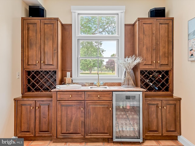 bar featuring wine cooler, sink, and light tile patterned floors