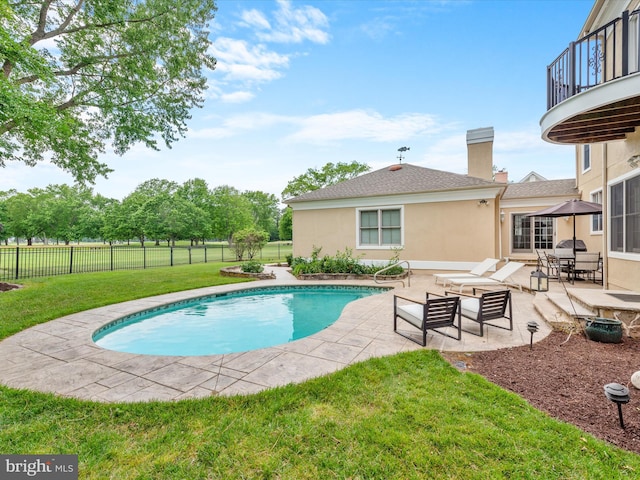 view of swimming pool with a yard and a patio