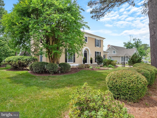 colonial-style house with a front lawn