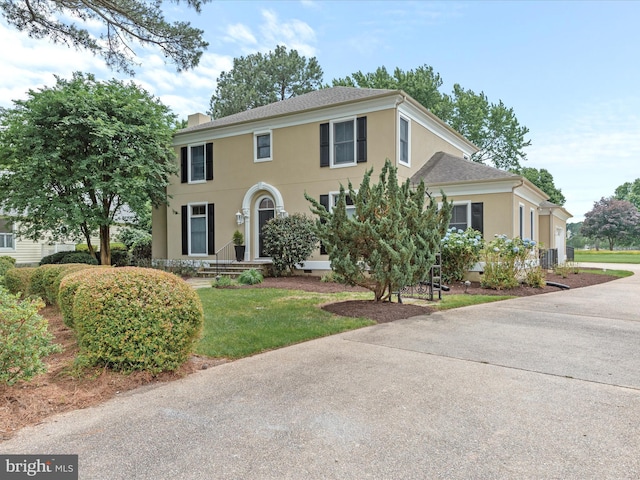 view of front facade featuring central AC and a front lawn