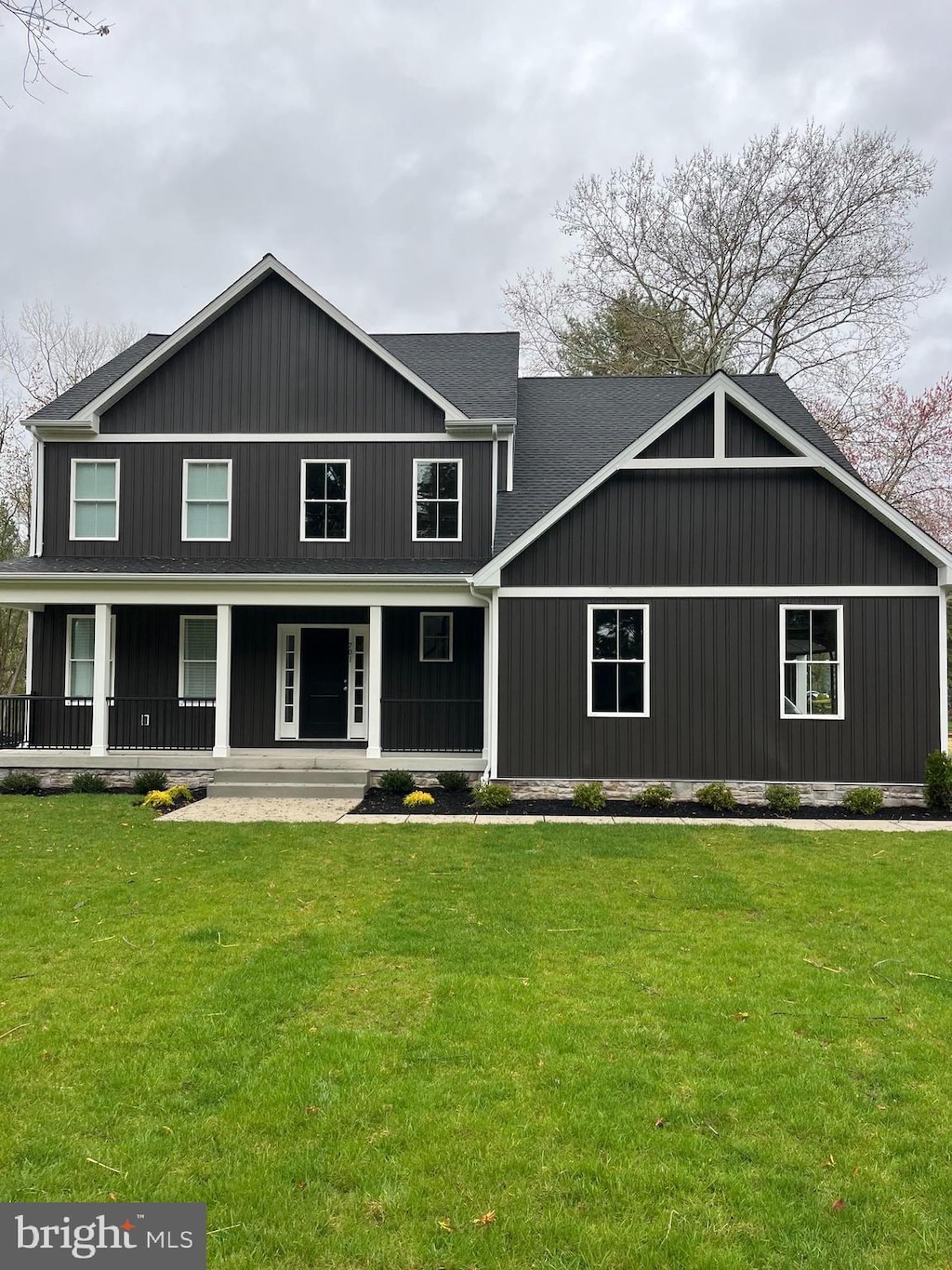 view of front of home featuring covered porch and a front lawn