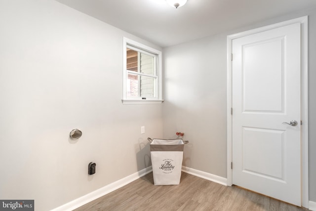 clothes washing area with light wood-type flooring