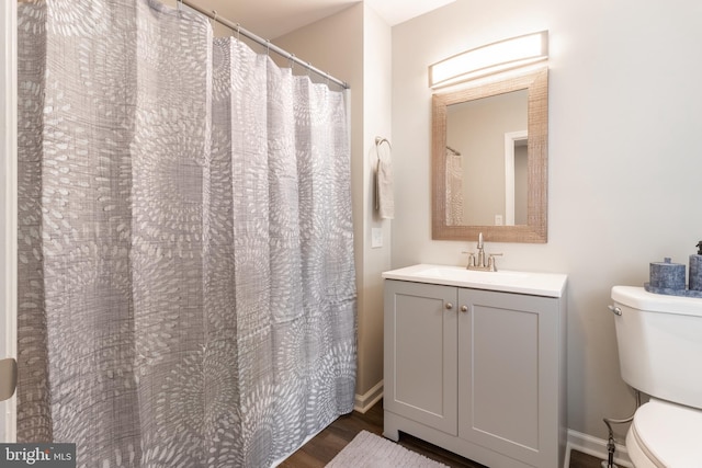 bathroom with hardwood / wood-style flooring, vanity, and toilet