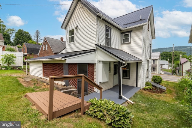 back of house featuring a patio area and a lawn