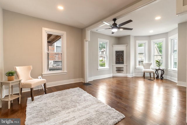 living room featuring dark hardwood / wood-style flooring and ceiling fan