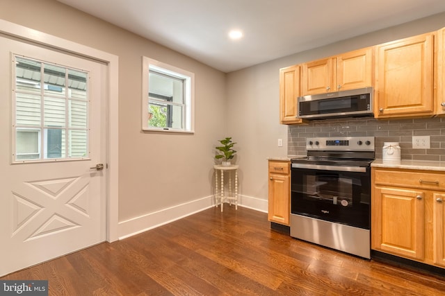 kitchen with decorative backsplash, appliances with stainless steel finishes, light brown cabinetry, and dark wood-type flooring