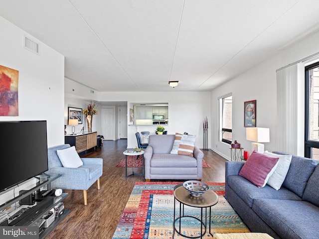 living room with plenty of natural light and dark hardwood / wood-style floors