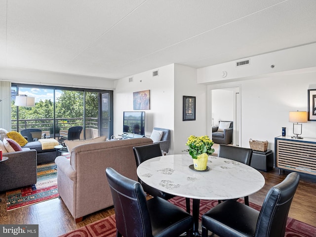 dining space featuring wood-type flooring and a textured ceiling