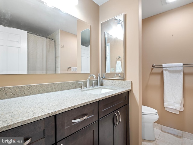 bathroom with tile patterned flooring, vanity, and toilet