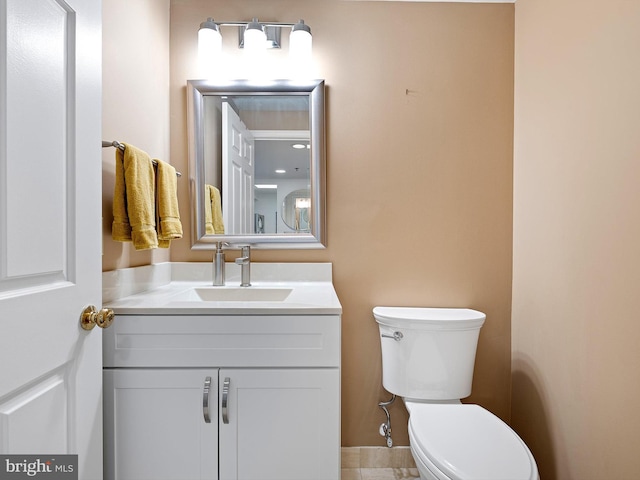 bathroom with tile patterned flooring, vanity, and toilet