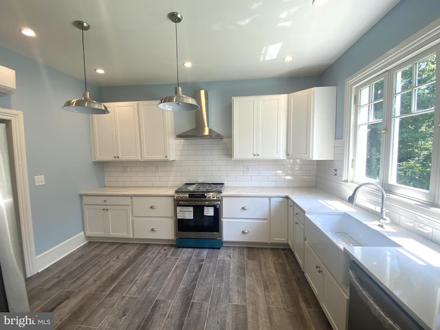 kitchen featuring pendant lighting, white cabinets, gas range, and wall chimney exhaust hood