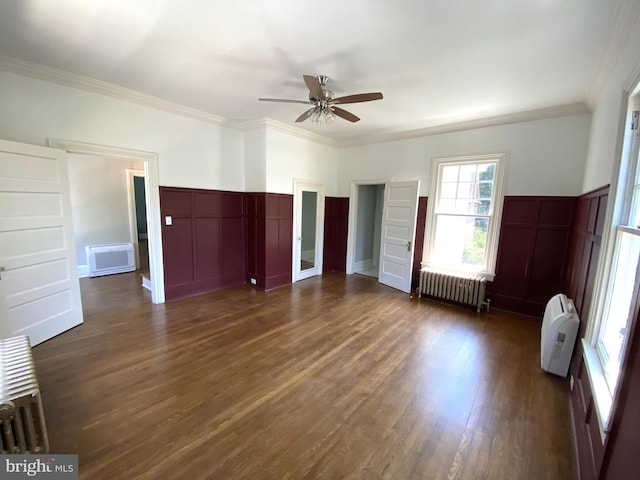 interior space with radiator, ornamental molding, dark hardwood / wood-style floors, and ceiling fan