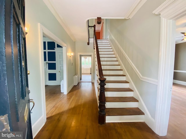 foyer with hardwood / wood-style floors, radiator heating unit, and ornamental molding