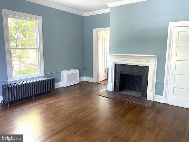 unfurnished living room with a brick fireplace, dark wood-type flooring, radiator heating unit, and ornamental molding