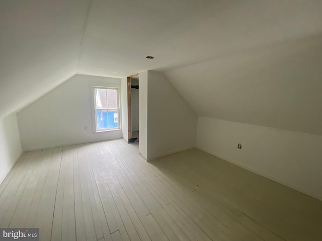 bonus room featuring lofted ceiling and light wood-type flooring