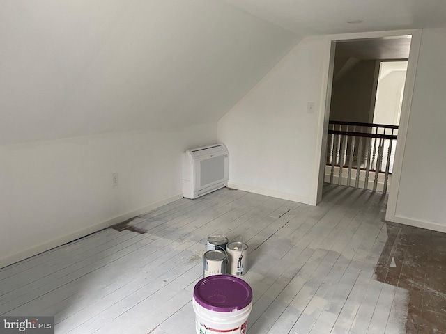 additional living space featuring lofted ceiling and light wood-type flooring