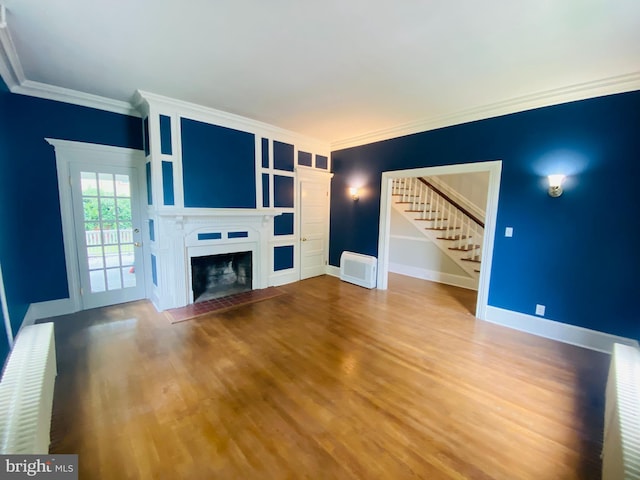 unfurnished living room featuring radiator, wood-type flooring, and ornamental molding