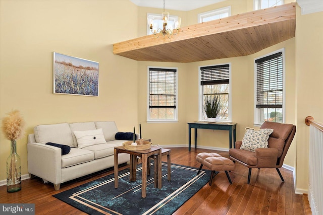 living room with a high ceiling, dark hardwood / wood-style floors, a wealth of natural light, and a chandelier