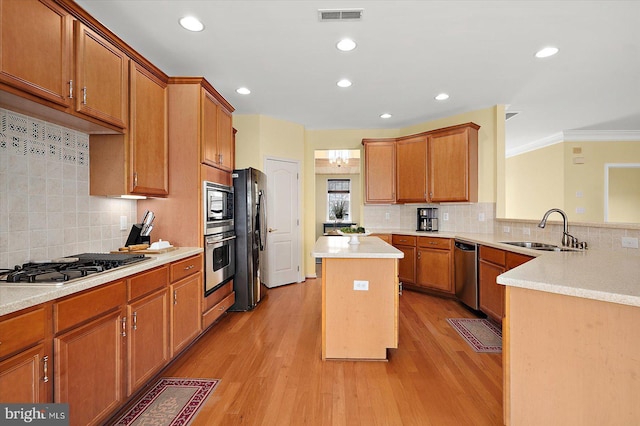 kitchen featuring sink, light wood-type flooring, stainless steel appliances, and a kitchen island