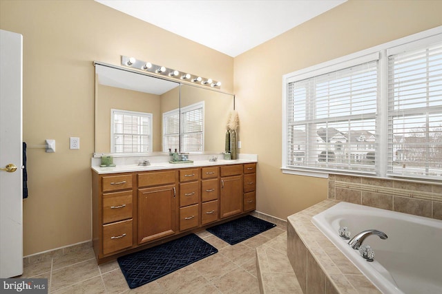 bathroom featuring tile patterned flooring, vanity, and tiled bath